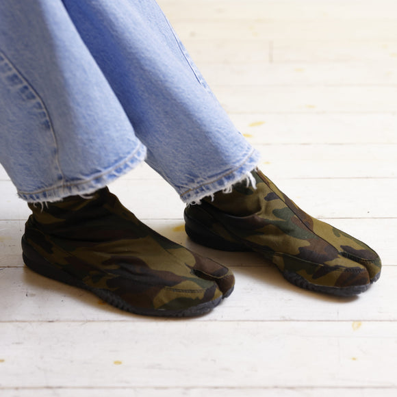 MEISAI green tabi shoes featuring a camouflage design and split-toe construction, shown worn for a comfortable, everyday look.