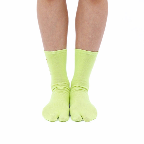 Person wearing long green Tabi Socks " Pixel Shika ", front view