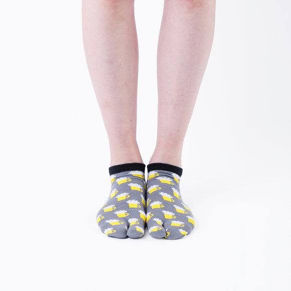 Person wearing short gray Tabi Socks " Beer ", front view