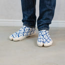 10.	Indoor side view of blue Tabi Shoes "TIGRE" styled with a long denim.